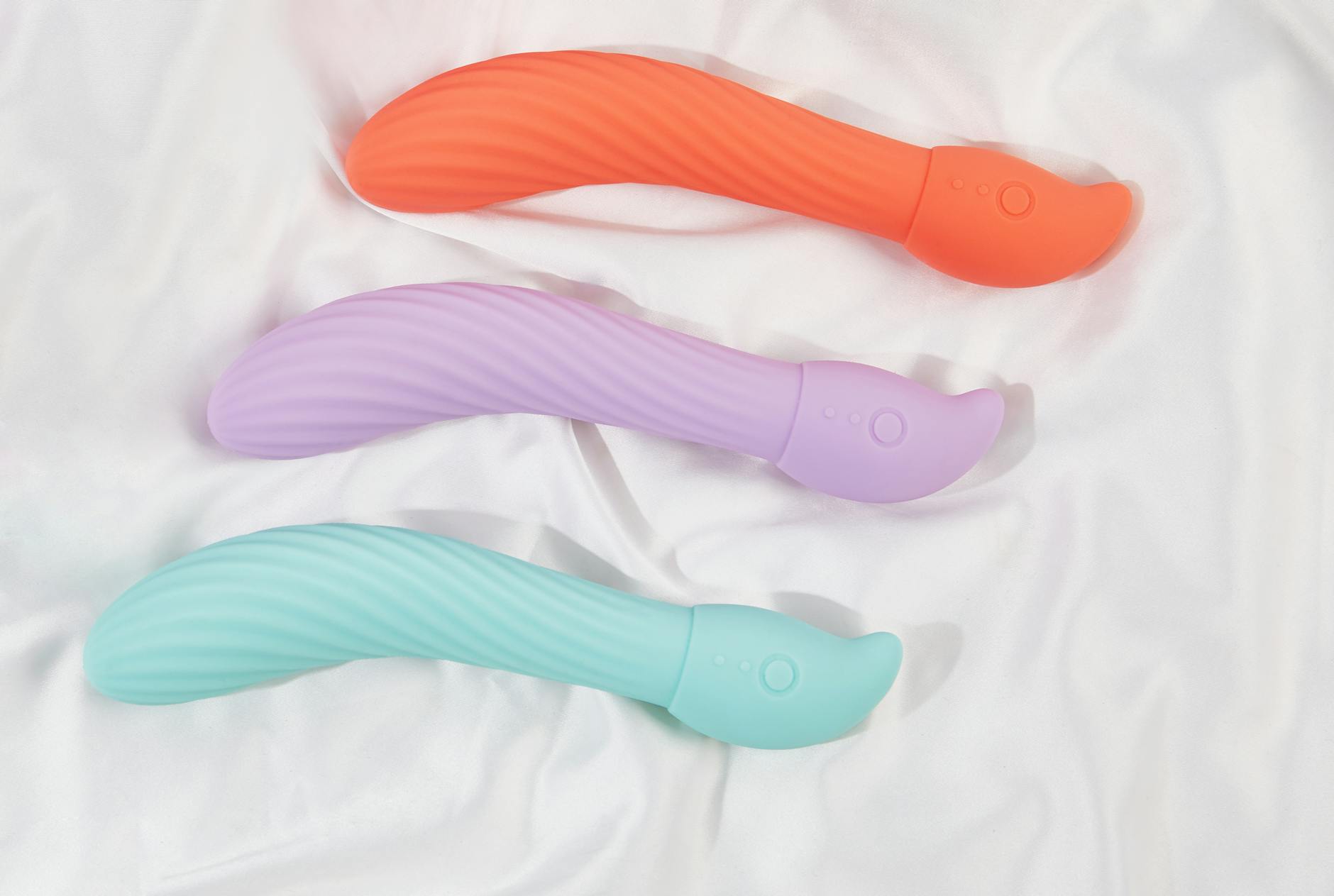 A young couple standing together indoors, holding a blue vibrator, symbolizing modern intimacy and openness to exploring pleasure together.