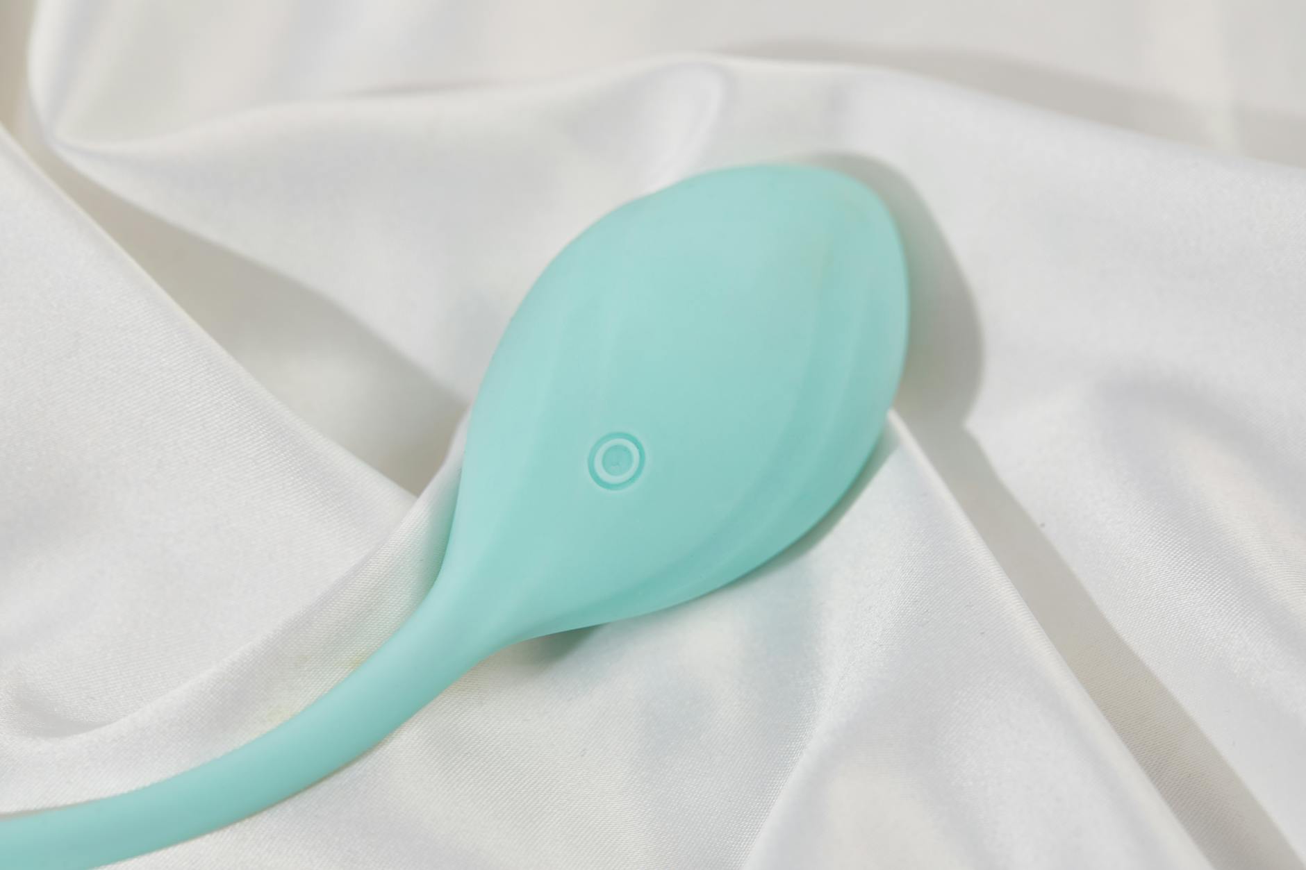 A young couple standing together indoors, holding a blue vibrator, symbolizing modern intimacy.